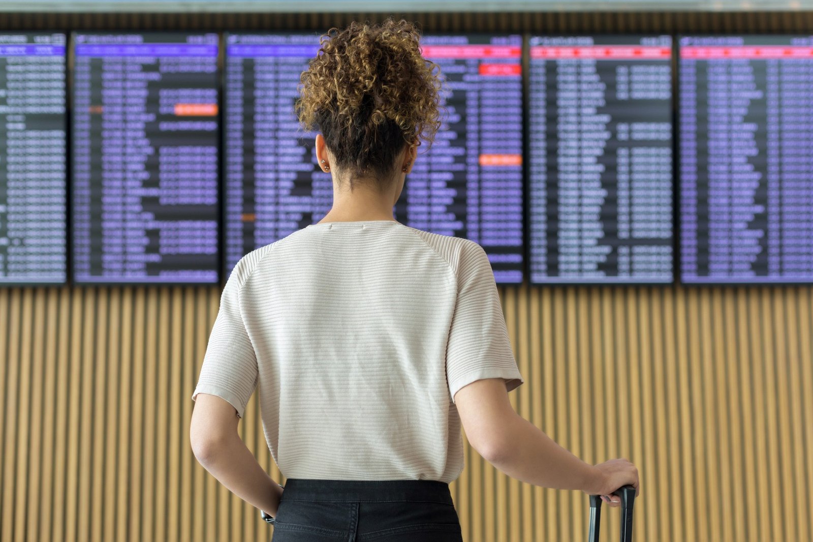 Mulher checando os horários de voos no aeroporto